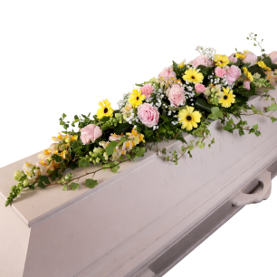 Kista med blomsterarrangemang av rosa rosor, gula blommor och gröna blad.